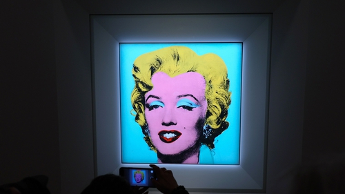 A guest takes a photo during Christie's announcement that they will offer Andy Warhol's Shot Sage Blue Marilyn painting of Marilyn Monroe at Christie's on March 21, 2022 in New York City. Getty.
