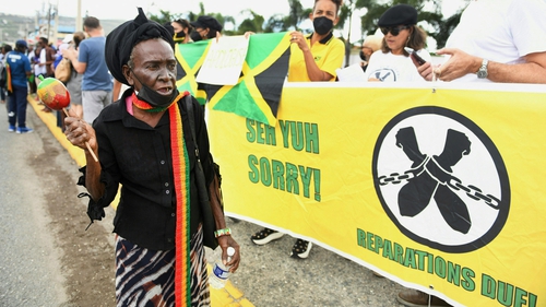 Dozens of people gathered outside the British High Commission in Kingston, singing traditional Rastafarian songs and holding banners with the phrase "seh yuh sorry" - a local patois phrase urging Britain to apologise
