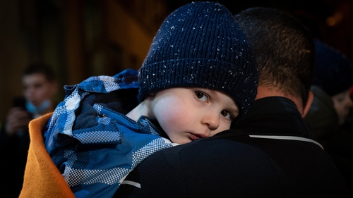 A taxi driver takes a Ukrainian child in his arms after they arrived in Madrid