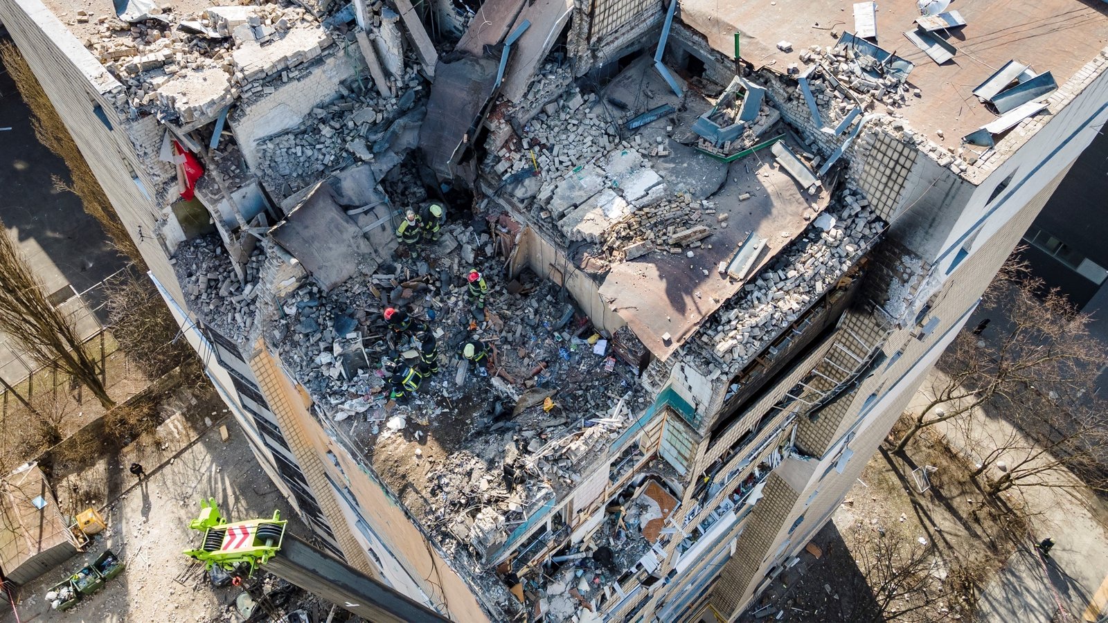 Image - Firefighters work in the rubble of a residential building which was hit by debris from a downed rocket in Kyiv
