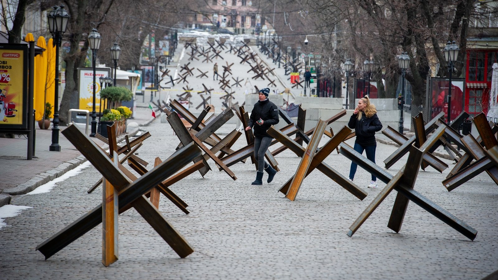 Image - People walk among anti-tank barriers placed to protect historic landmarks in expectation of a Russian assault on the strategic Black Sea port city of Odessa