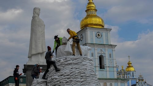 Ukrainian volunteers pile sandbags to protect the monuments from missile attacks in Kyiv