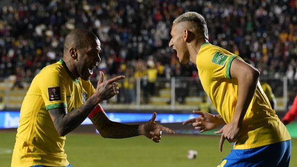 Brazil's Richarlison celebrates with teammate Dani Alves after scoring the fourth goal against Bolivia on Wednesday
