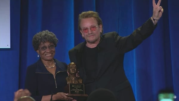 Cynthia Ackron Baldwin presenting the award to Bono