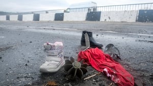 Clothes and shoes near the remnants of a mortar on a bridge over the Irpin River in Demydiv on the outskirts of Kyiv