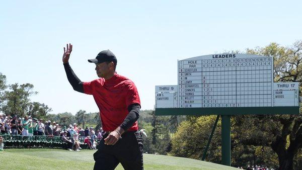 Tiger Woods waves to the crowd on the 18th green after finishing his round