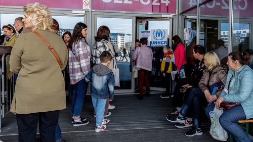 Ukrainian refugees queue in Poland waiting to be registered by UNHCR after escaping the war in their country