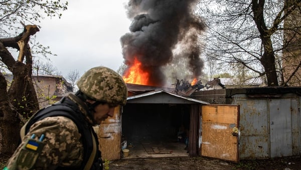 A Ukrainian soldier walks in front of a burning garage following a Russian artillery strike in Kharkiv, the second biggest city in the country. Photo: Getty Images