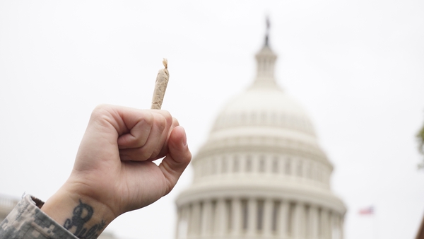 A demonstrator at an event in Washington holds a joint up in imitation of the Capitol Building