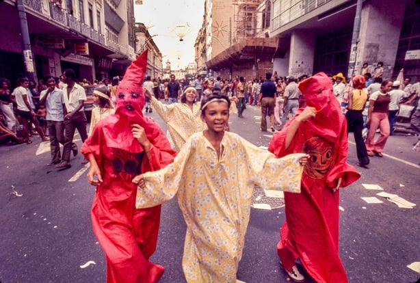 Crianças disfarçadas correm pela rua durante o Carnaval de 1975 