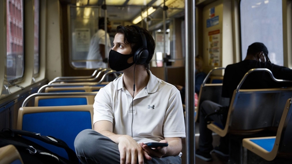 A man wears a mask while riding a Brown Line train in Chicago