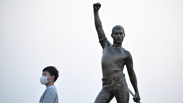 A boy walks past a statue of British rock group Queen's lead singer Freddie Mercury after it was unveiled by organisers outside a restaurant on the northern coast of Jeju. (Photo by Anthony WALLACE / AFP) (Photo by ANTHONY WALLACE/AFP via Getty Images)