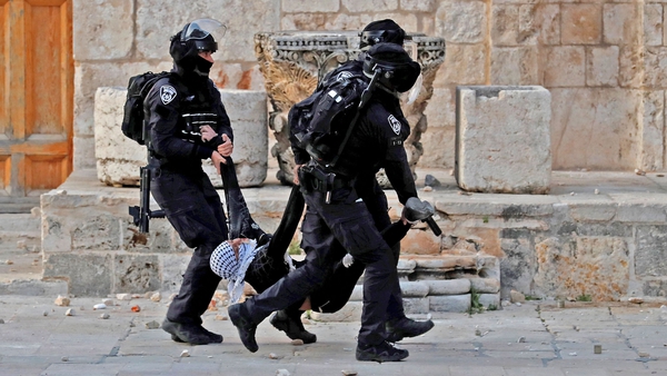 Israeli police with a wounded Palestinian demonstrator at Jerusalem's Al-Aqsa mosque today