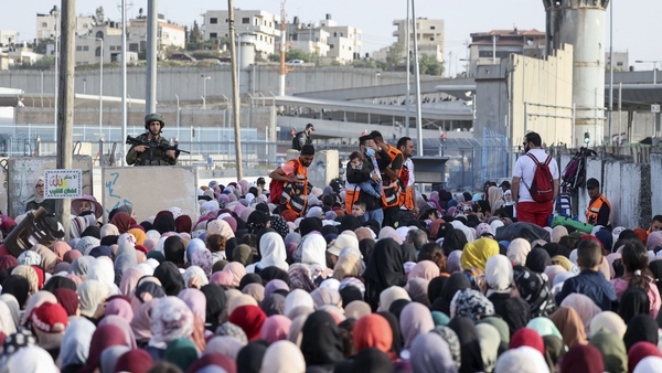 Israeli security forces stand guard as Palestinians at the Qalandia checkpoint in the occupied West Bank, to cross into Jerusalem to reach the Al-Aqsa Mosque this week