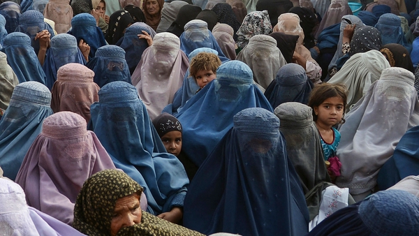 Women wait to receive a food donation from the Afterlife foundation during Ramadan in Kandahar