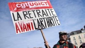 A demonstrator holds a placard reading 'Retirement before arthritis' during a rally in Nantes in France