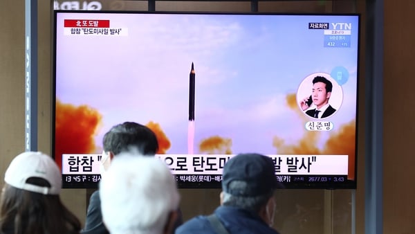 People watch a television broadcast showing a file image of a North Korean missile launch at the Seoul Railway Station