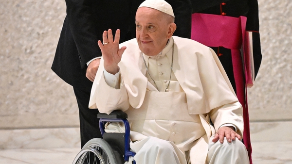 Pope Francis waved as he was wheeled into the Vatican's general audience hall