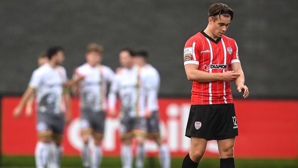 A dejected Matty Smith of Derry City as Bohemians celebrate their opener in the background