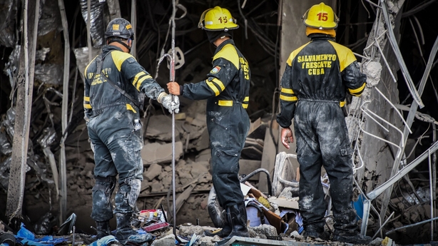 Rescue workers remove debris from the ruins of the Saratoga Hotel
