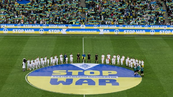 The teams of Borussia Monchengladbach and Ukraine standing in front of a 'Stop War' banner at Borussia-Park