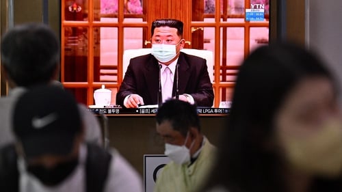 A TV screen at a train station in Seoul shows a news broadcast of North Korea's leader Kim Jong Un appearing in a face mask on television for the first time to order nationwide lockdowns