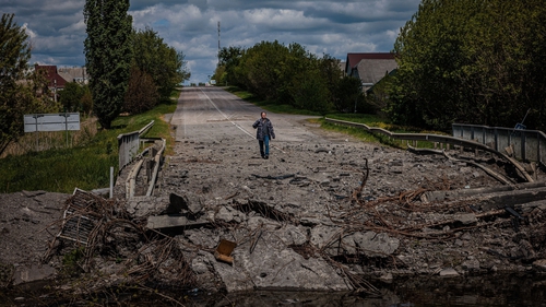 A man at a destroyed bridge on the road near the village of Rus'ka Lozova, north of Kharkiv