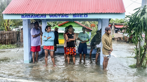 Residents stand in a flooded area in the town of Guiuan in the Philippines after Super Typhoon Rai passed in December
