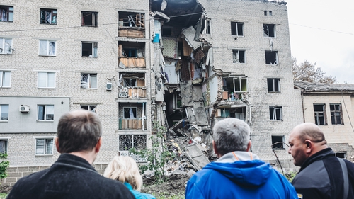 Neighbours look at a bombed building in Bakhmut in the Donbas, Ukraine