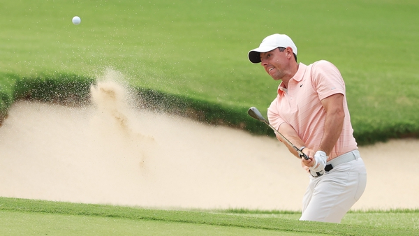 Rory McIlroy escapes the bunker on 18