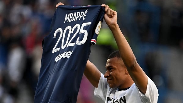 Mbappe poses with a jersey after the announcement that he is staying at the Parc des Princes-based club