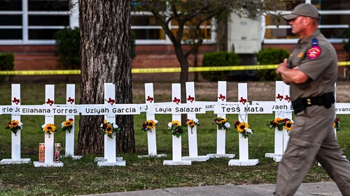 A police officer walks past a memorial for the victims of the Uvalde, Texas school shooting. Photo: Chandan Khanna/AFP/ Getty Images