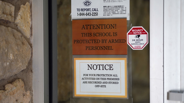 Sign at the Utopia Independent School warns that school personnel are armed