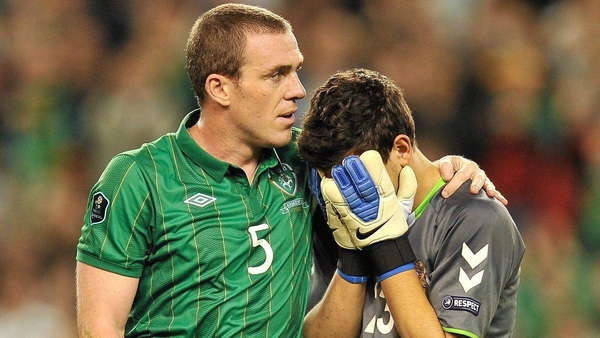 Richard Dunne comforts Armenia's second choice goalkeeper, who made an error for his goal, in 2011