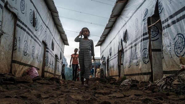 Internally displaced children run in an alley of a camp in the town of Azezo, Ethiopia