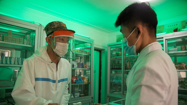 A doctor from the Korean People's Army gives a man prescription medicine at a pharmacy in Pyongyang