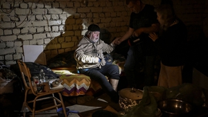 A man helps his father in the basement of where they are living, in Lysychansk on 26 May