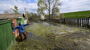 Maria Didovets (82) in flood waters outside her home on 30 April after a Russian strike on a nearby dam