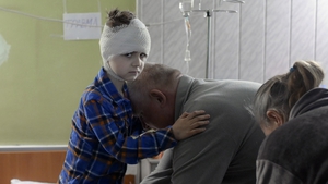 Misha, 5, who was injured during a Russian strike which killed his mother, is helped
by his grandfather to get dressed, in the basement of a hospital in Mykolaiv, on 26 March