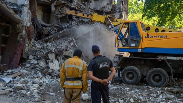 Rescuers demolish the remains of a house that was hit by Russian shelling in Kharkiv