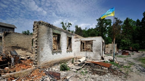 A Ukrainian flag waves over a house destroyed by shelling in the village of Moshchun, Kyiv region