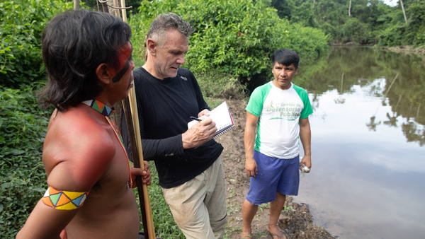 Dom Phillips (C) talks to two indigenous men in Aldeia Maloca Papiú, Roraima State, Brazil in 2019