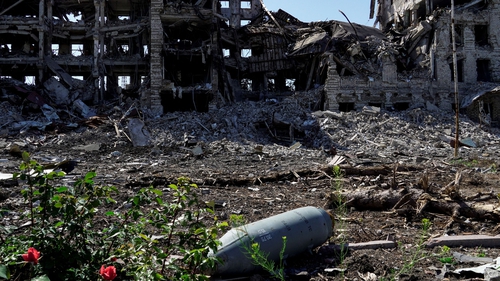 An unexploded aviation bomb FAB-250 is pictured in front of a destroyed building in Mariupol