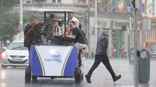 A group of people were caught in a sudden downpour of rain on O'Connell Bridge in Dublin this afternoon (Pic: RollingNews.ie)