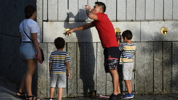 People drink water to cool down in Madrid, Spain