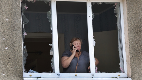 A woman looks out from her apartment damaged by a projectile fired from Russian troops today in Bakhmut, Ukraine