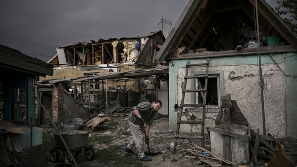A man cleans his destroyed house from debris today after a strike in the city of Dobropillia in the eastern Ukrainian region of Donbas