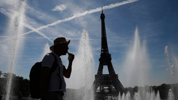 A man cools off by the Trocadero fountains, amid high temperatures in Paris on 16 June
