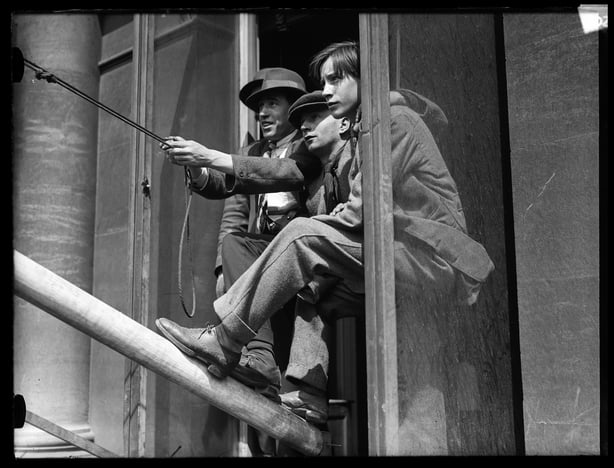 Young men in a window lowering the Union Jack Flag at Freemasons' Hall (1922)