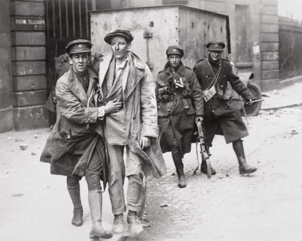 Bedraggled man being brought out of the ruins of the Four Courts